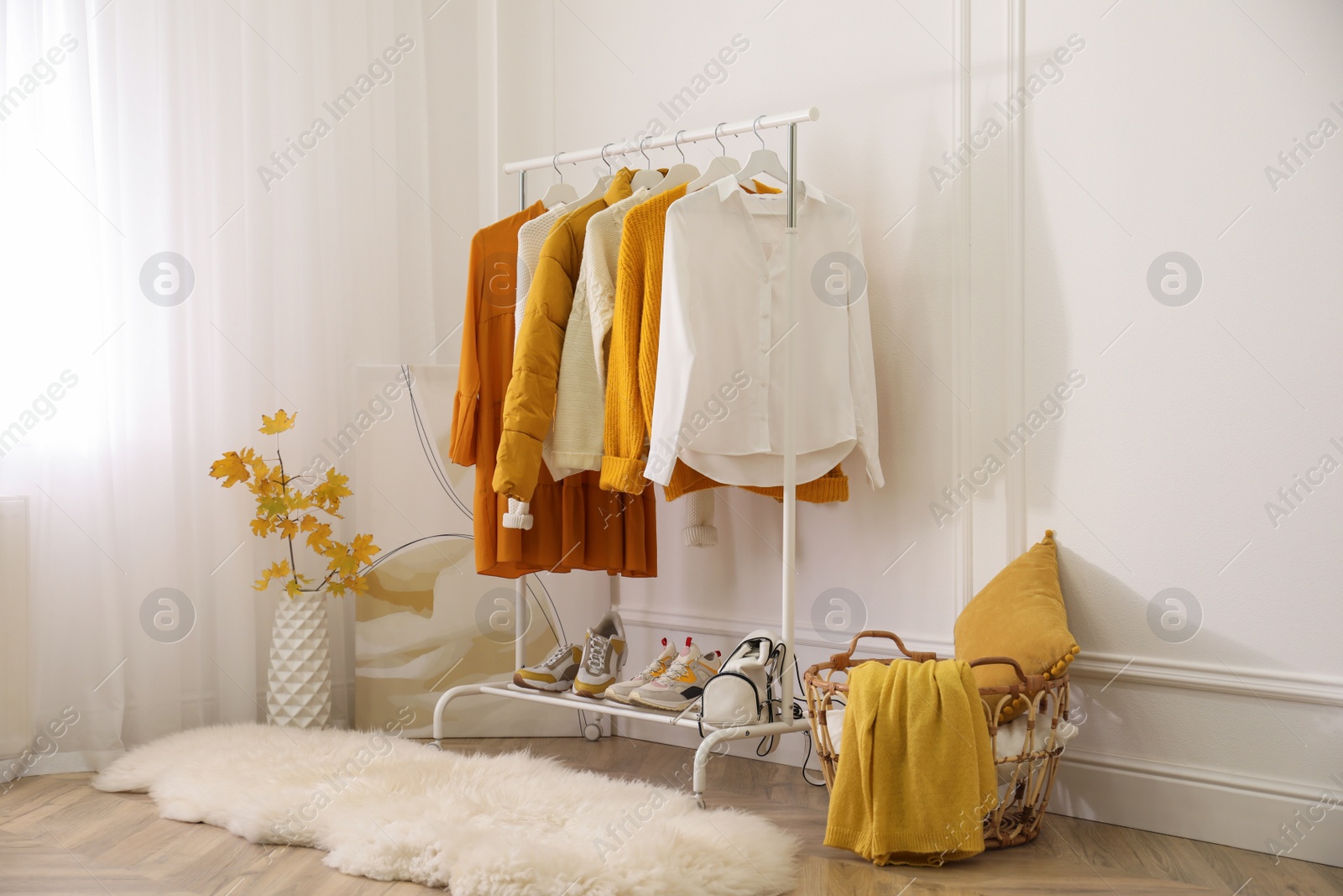 Photo of Rack with stylish warm clothes, shoes and accessories in modern dressing room