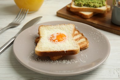 Photo of Delicious breakfast with egg and toasted bread served on white wooden table