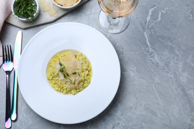 Photo of Delicious risotto with cheese on grey marble table, flat lay. Space for text