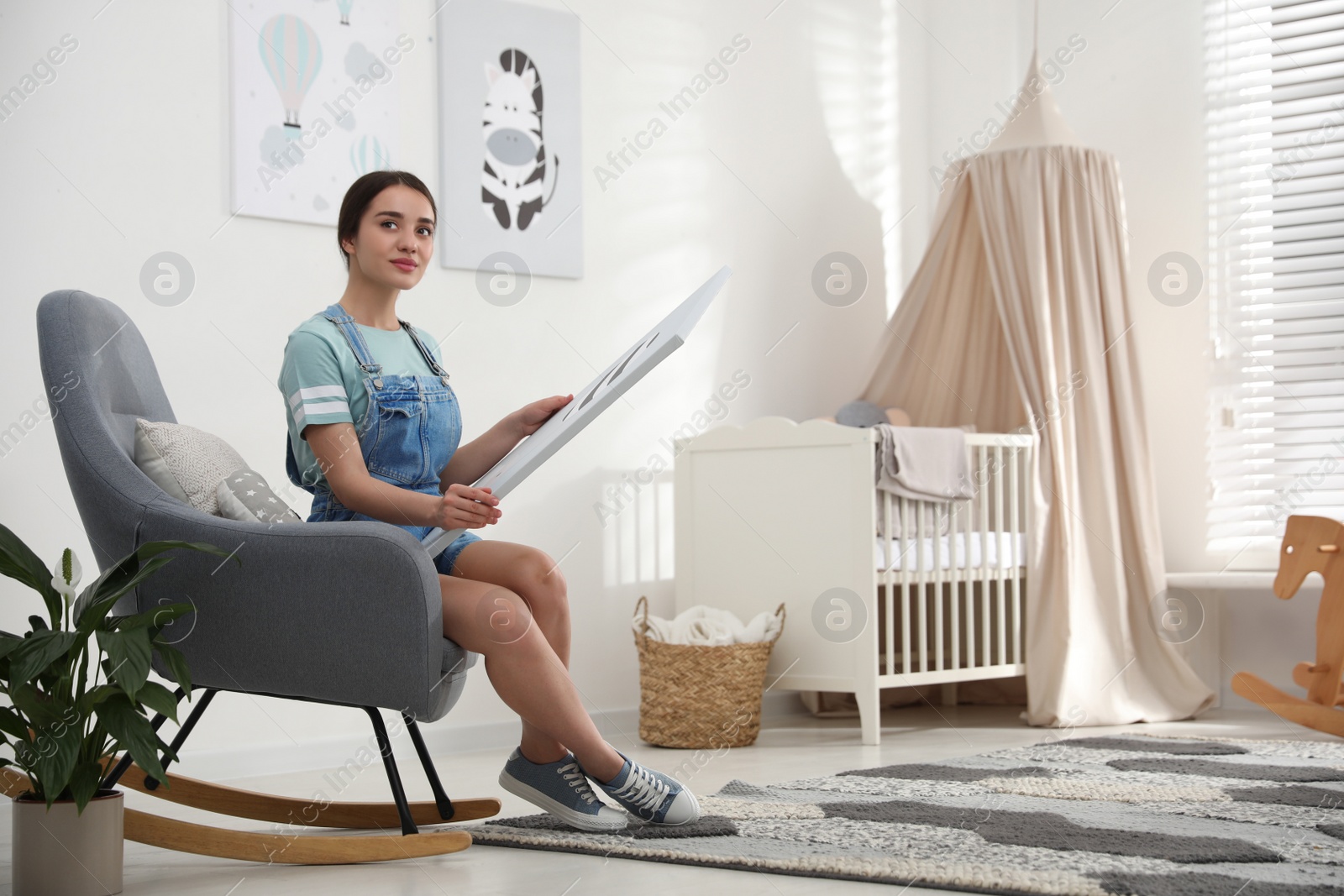 Photo of Decorator with picture sitting indoors. Children's room interior design