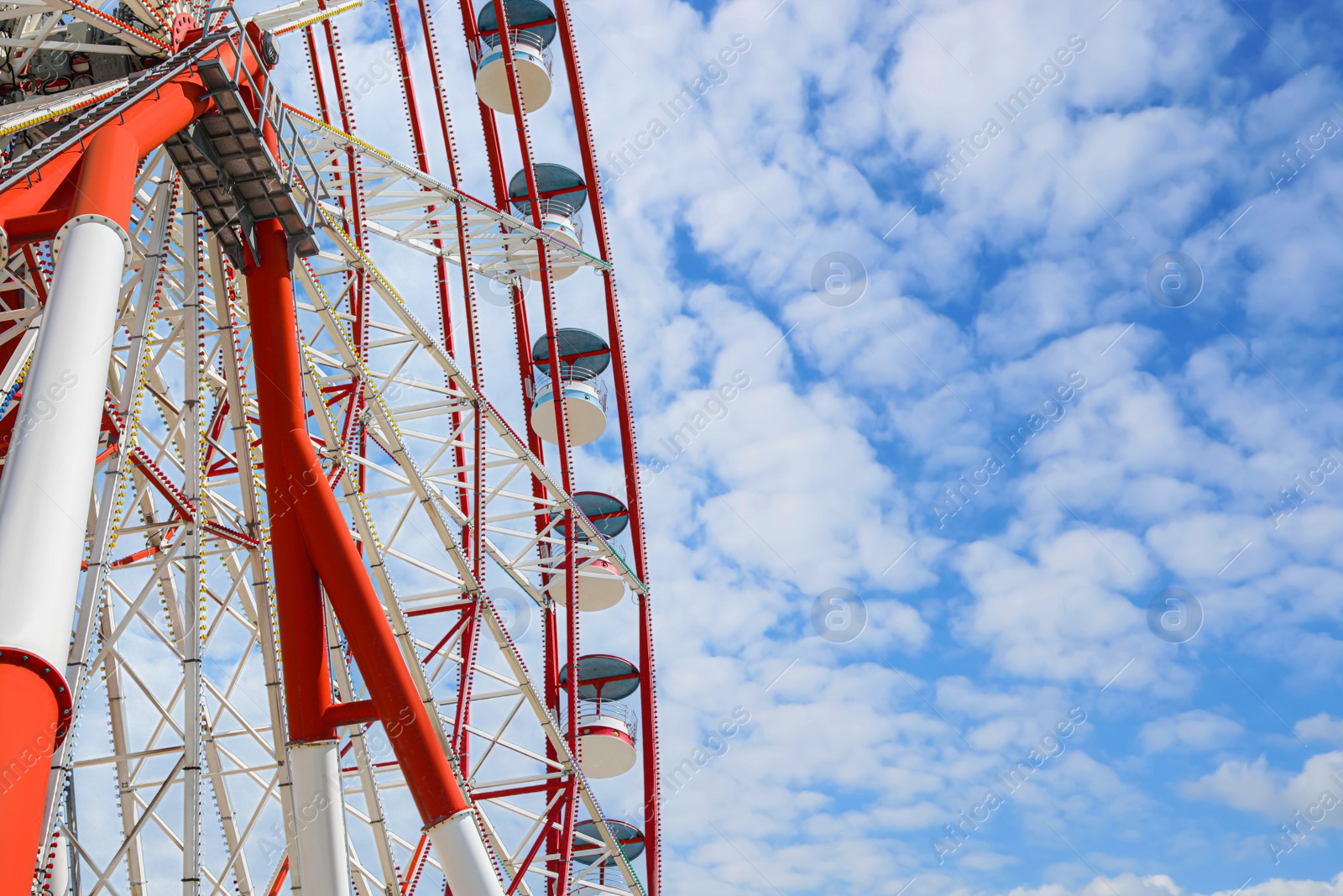 Photo of Beautiful large Ferris wheel against blue sky, low angle view