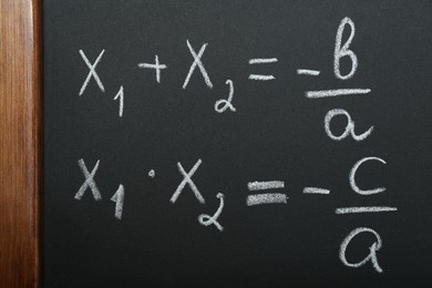 Photo of Many different math formulas written on chalkboard, closeup