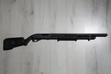 Photo of Shotgun on wooden background, top view. Firearm