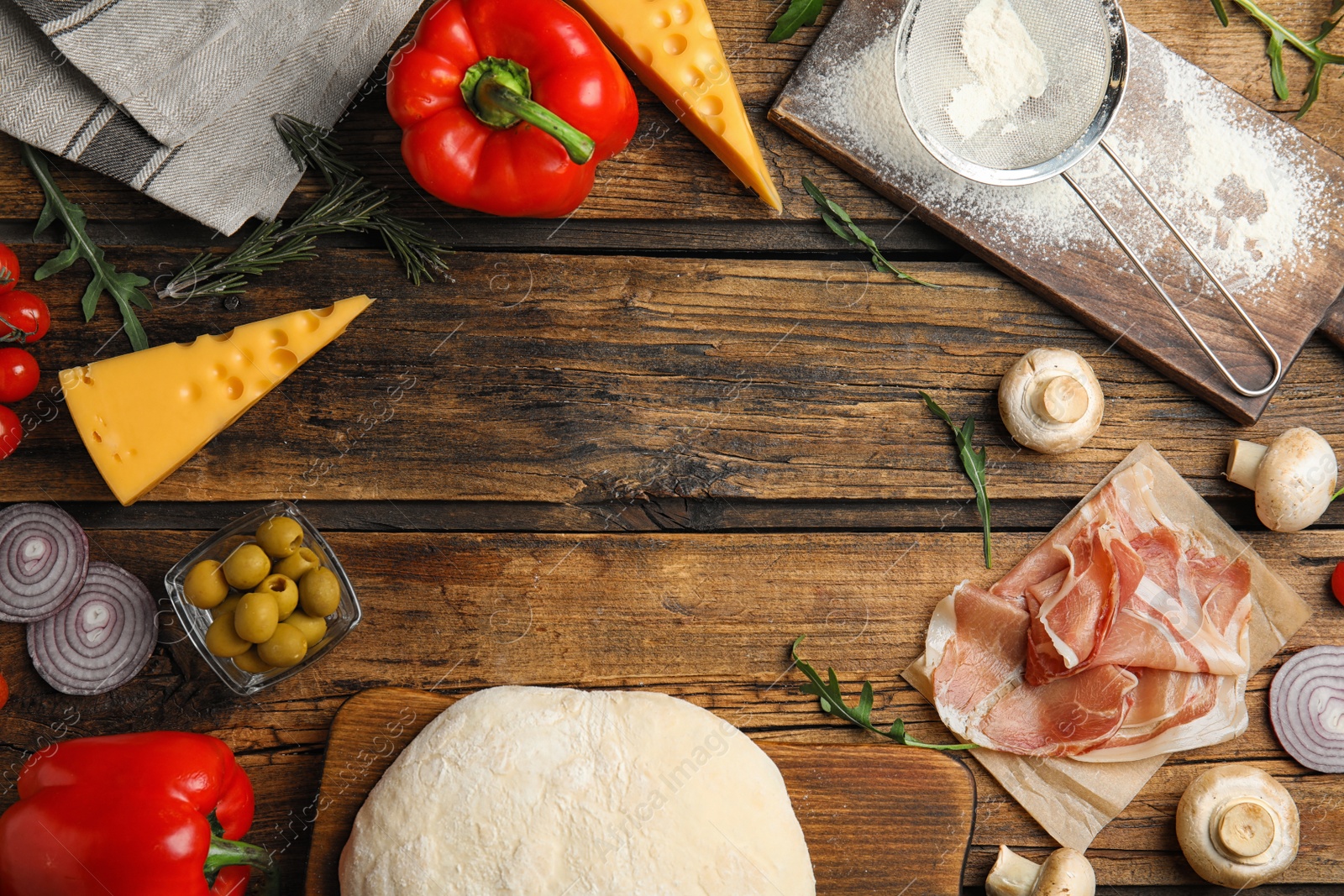 Photo of Flat lay composition with dough and fresh ingredients on wooden table, space for text. Pizza recipe