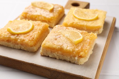 Photo of Tasty lemon bars on white table, closeup