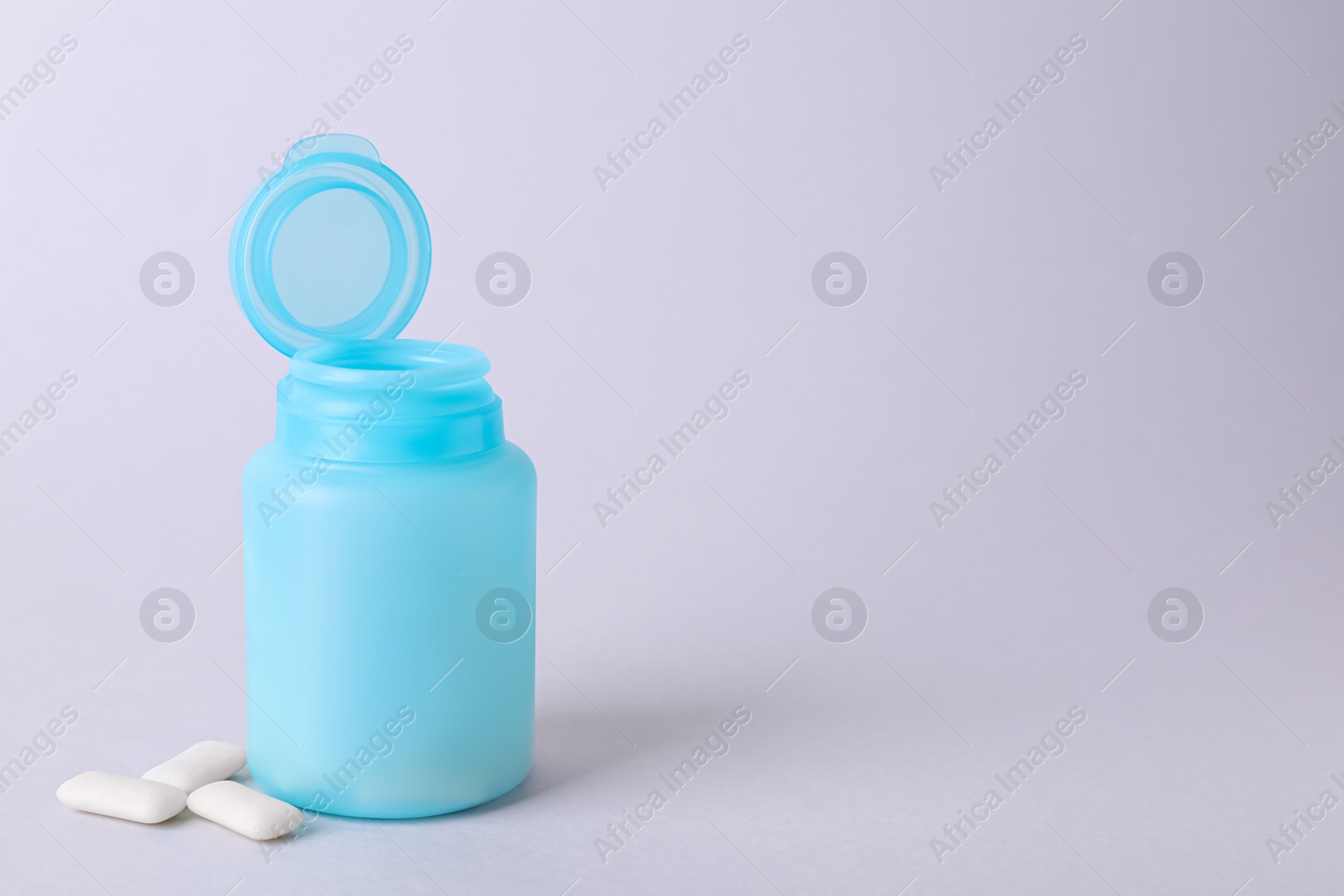 Photo of Jar with chewing gums on light grey background. Space for text