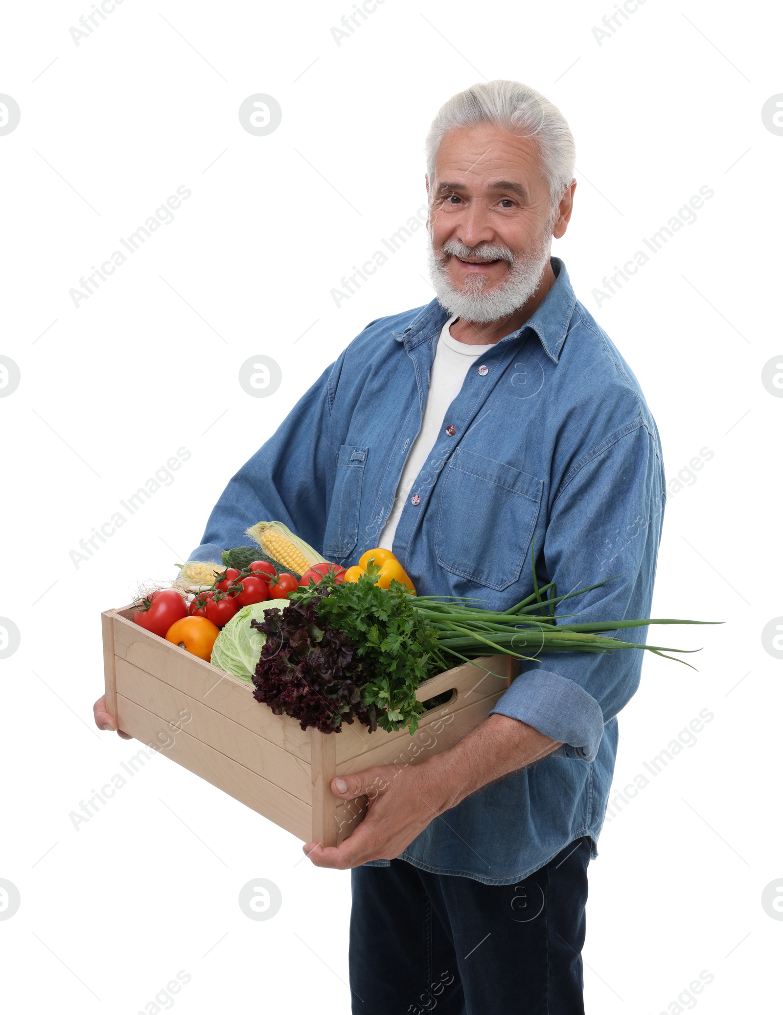 Photo of Harvesting season. Happy farmer holding wooden crate with vegetables on white background