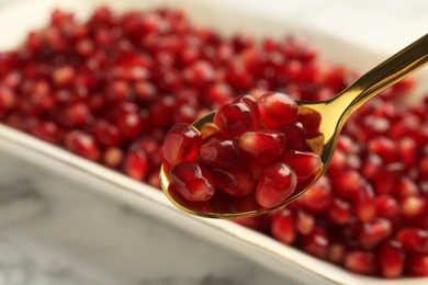Photo of Eating ripe juicy pomegranate grains at table, closeup. Space for text