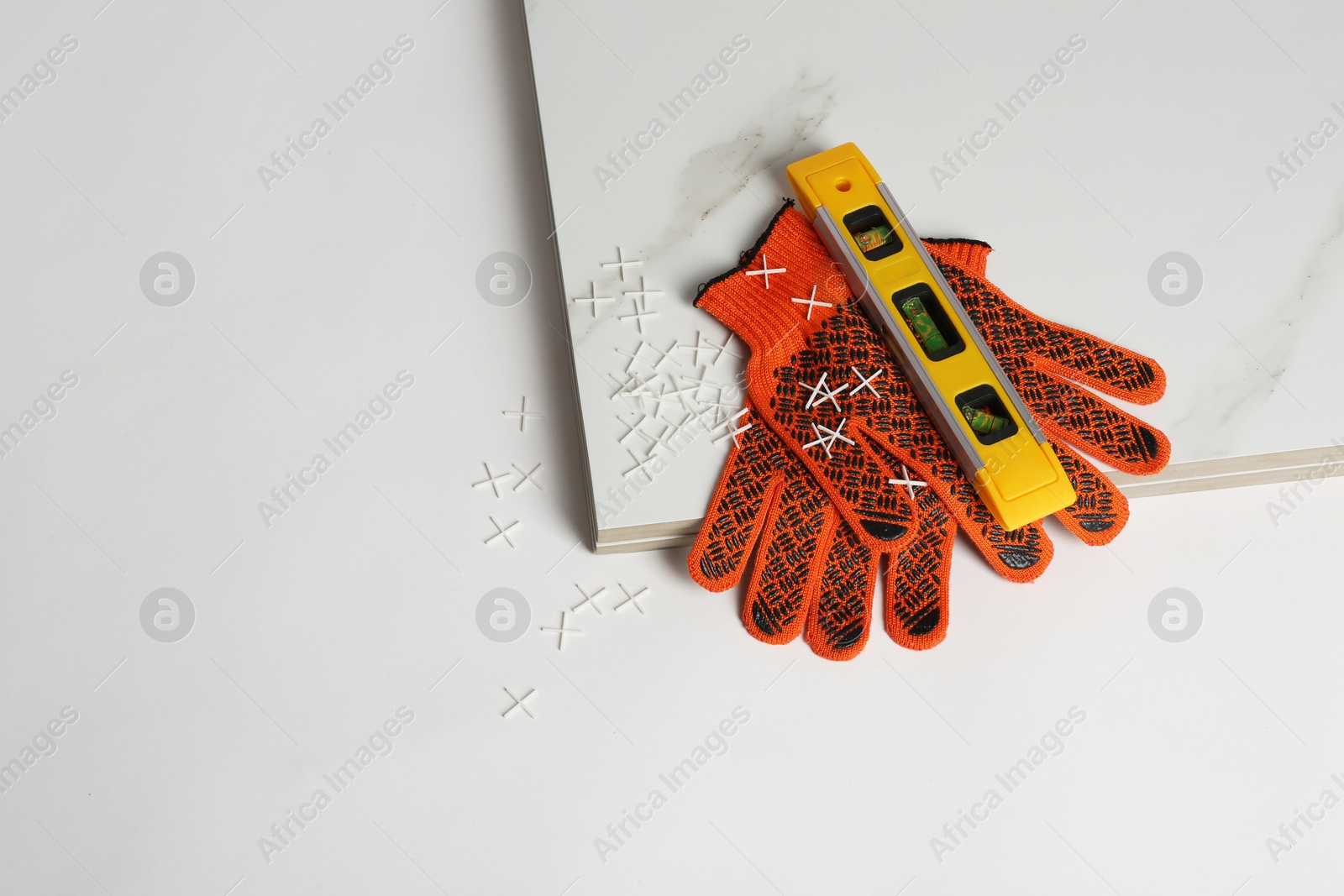 Photo of Composition with ceramic tiles and gloves on white background, top view