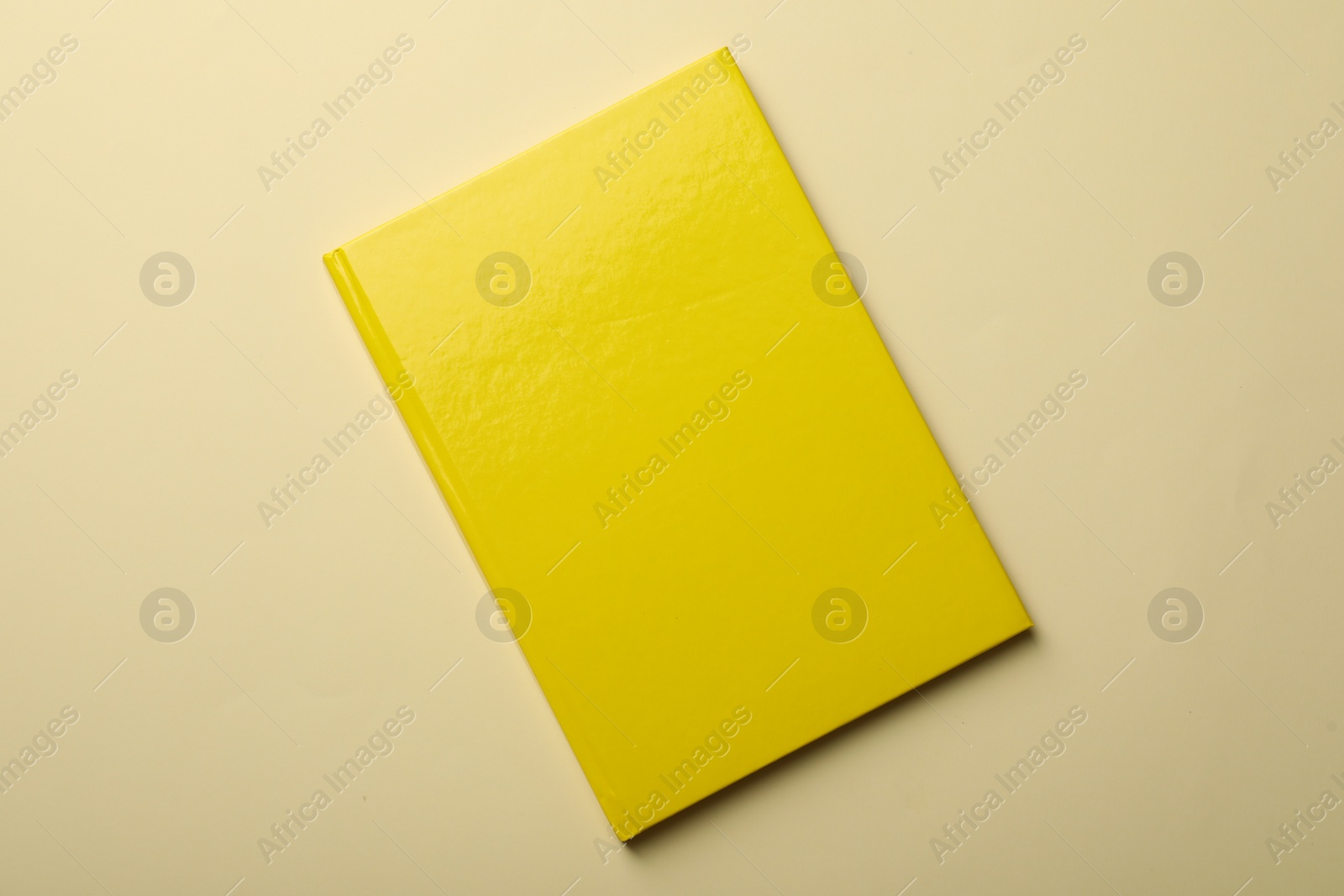 Photo of New yellow planner on beige background, top view