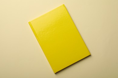 Photo of New yellow planner on beige background, top view