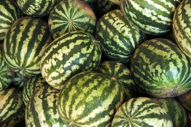 Delicious ripe watermelons as background, top view