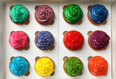 Photo of Different cupcakes with cream in box, closeup