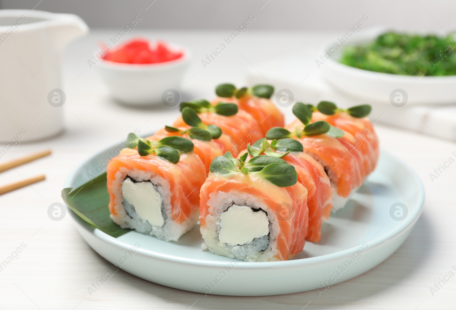 Photo of Tasty sushi rolls with salmon served on white table