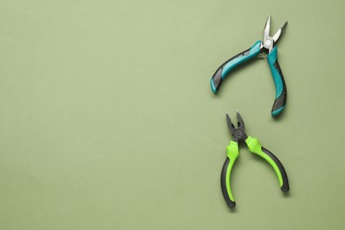 Pliers on olive background, flat lay. Space for text