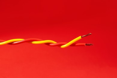 Two different electrical wires on red background