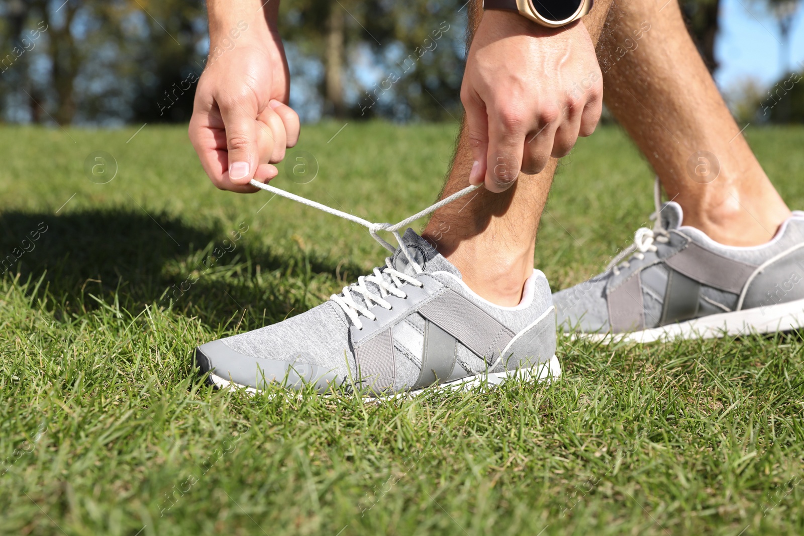 Photo of Sporty man tying shoelaces before running outdoors