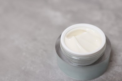 Photo of Body cream on grey table, closeup. Space for text