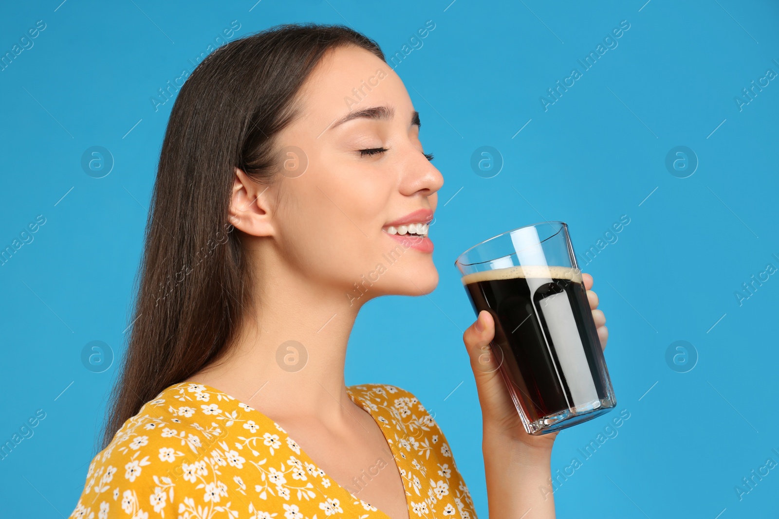 Photo of Beautiful woman with cold kvass on blue background. Traditional Russian summer drink