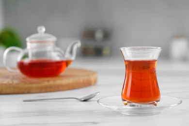 Glass of traditional Turkish tea on white marble table, space for text