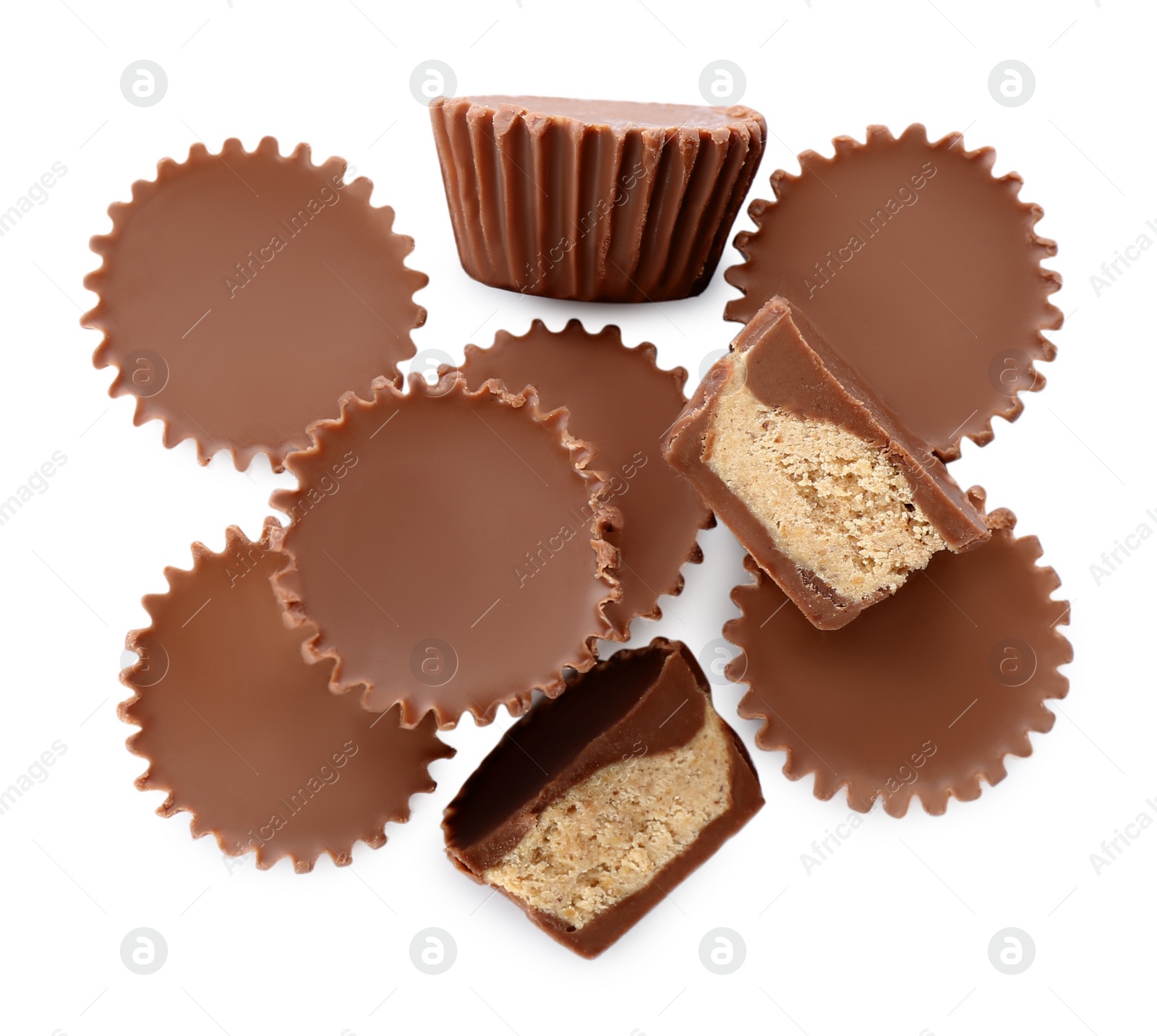 Photo of Cut and whole delicious peanut butter cups on white background, top view