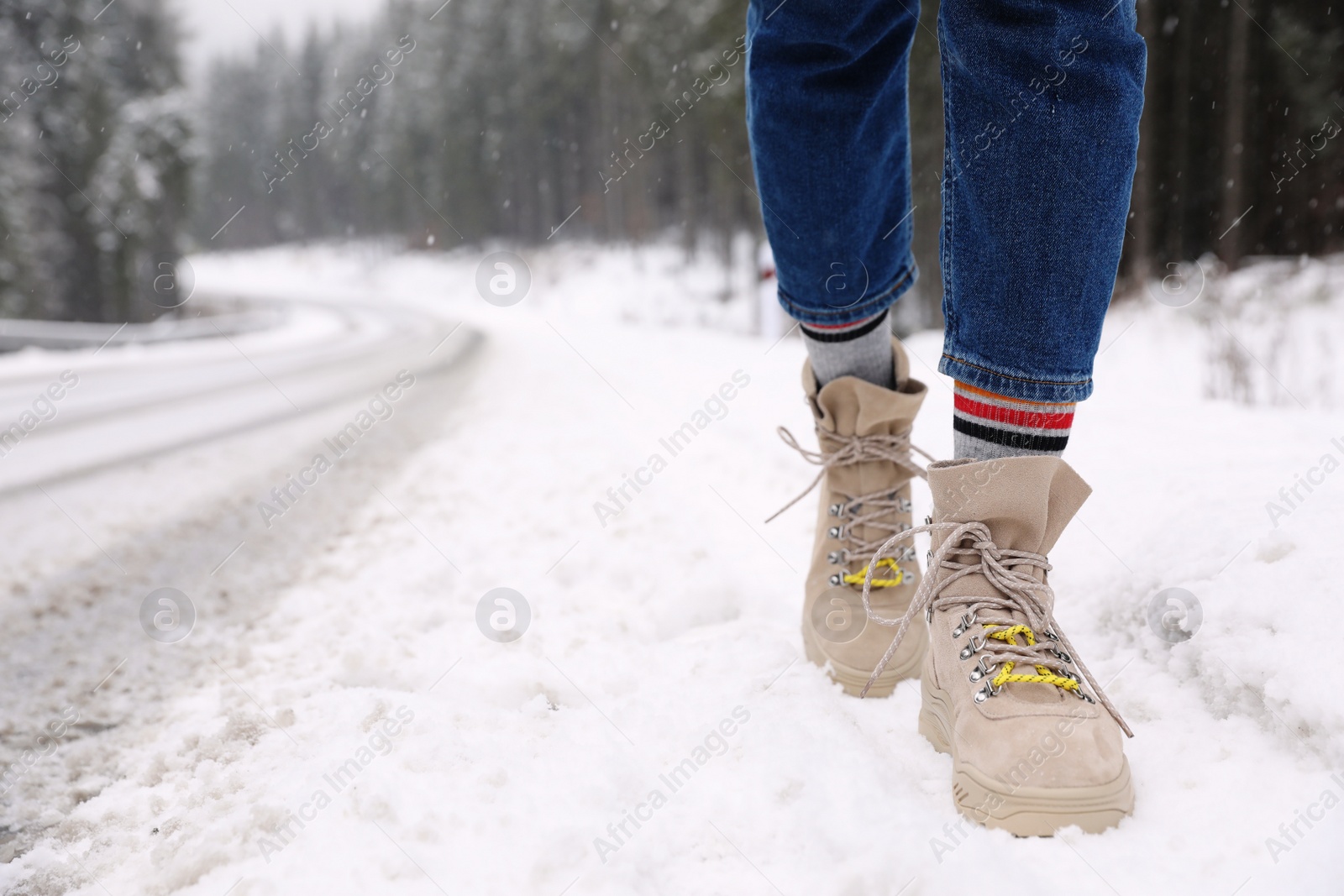 Photo of Woman walking outdoors on snowy winter day. Space for text