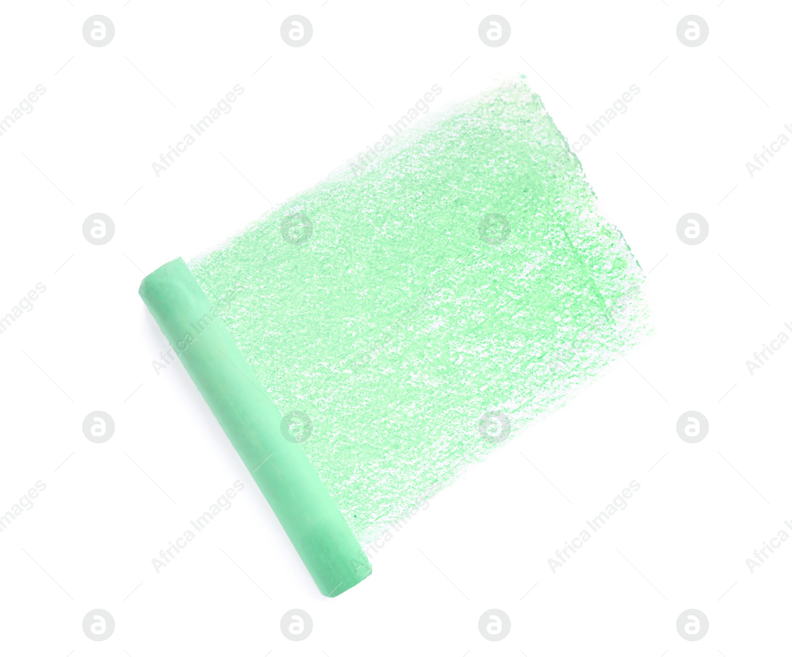 Photo of Green pastel chalk on sheet of paper with scribble, top view. Drawing material