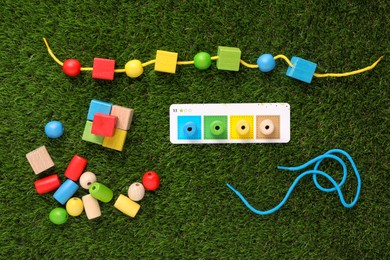 Photo of Educational toy for motor skills development on artificial grass, flat lay
