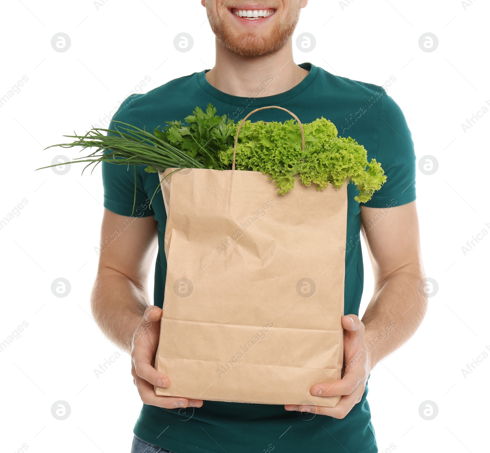 Photo of Young man with bag of fresh vegetables on white background, closeup