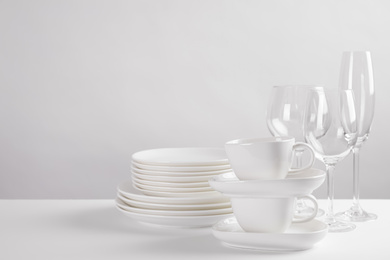 Photo of Set of clean dishes on white table