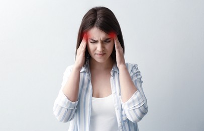 Image of Young woman suffering from migraine on white background
