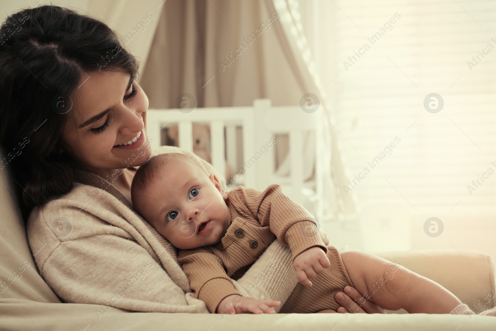 Photo of Happy young mother with her cute baby at home