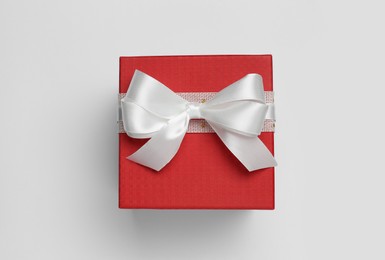 Gift box with bow on white background, top view