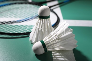 Photo of Feather badminton shuttlecocks and rackets on court, closeup