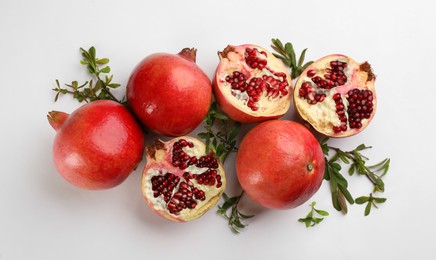 Flat lay composition with ripe pomegranates on white background