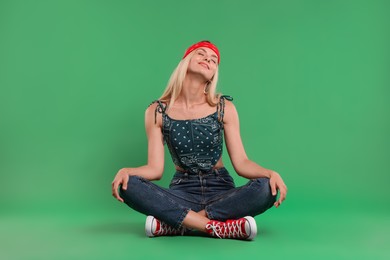 Portrait of happy hippie woman on green background