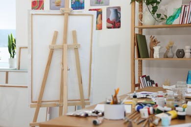 Photo of Wooden easel with canvas in artist's studio. Creative hobby