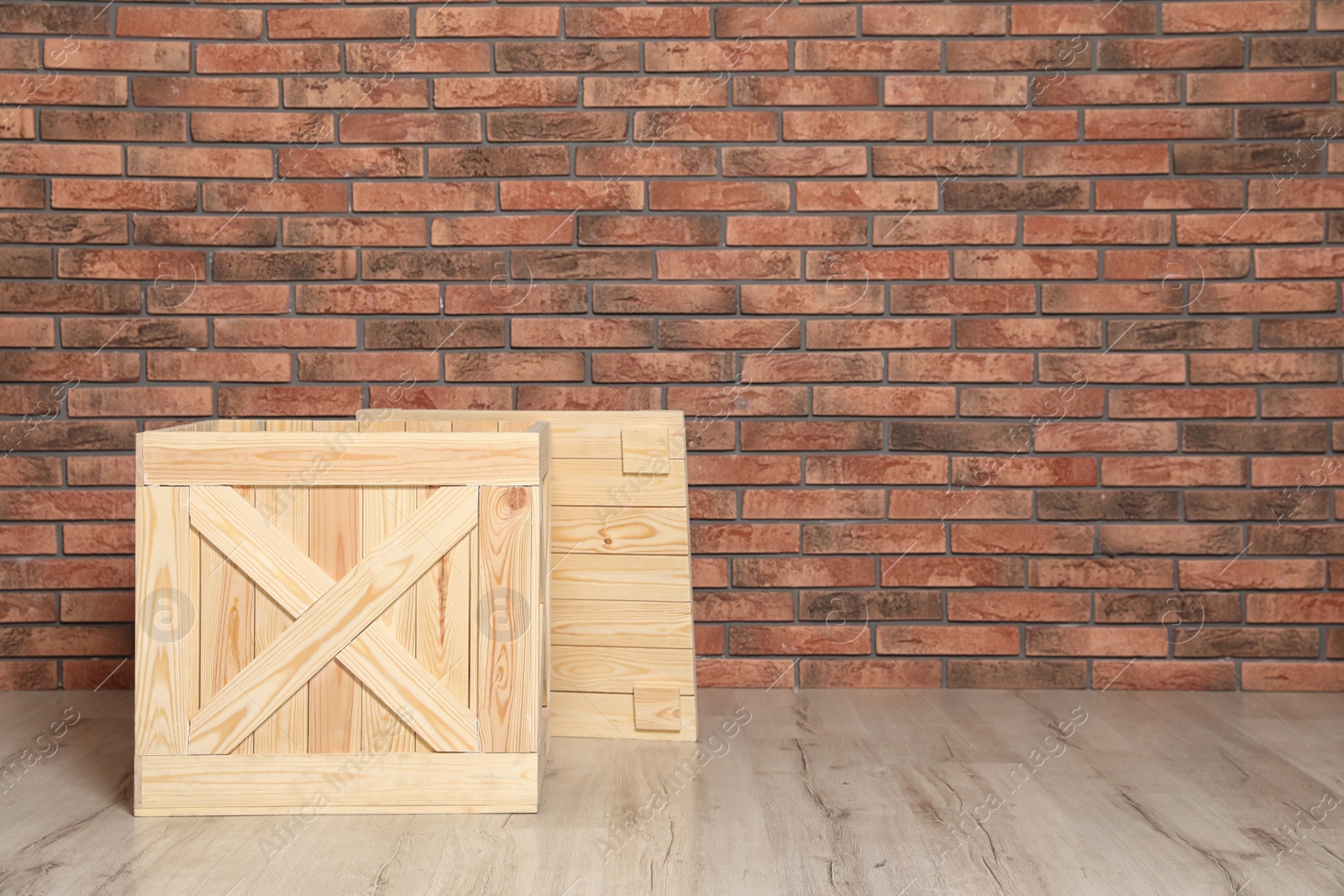 Photo of Wooden crate on floor at brick wall. Space for text