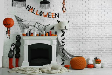 Photo of Room with fireplace and different decor for Halloween, space for text. Festive interior