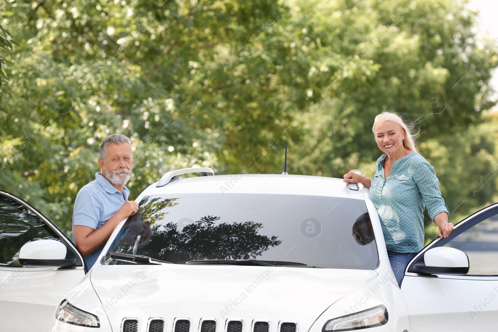 Photo of Happy senior couple standing near car outdoors