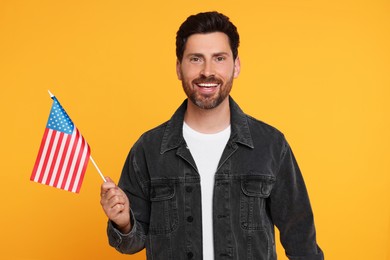 Photo of 4th of July - Independence Day of USA. Happy man with American flag on yellow background