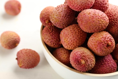 Fresh ripe lychees in bowl, closeup. Space for text