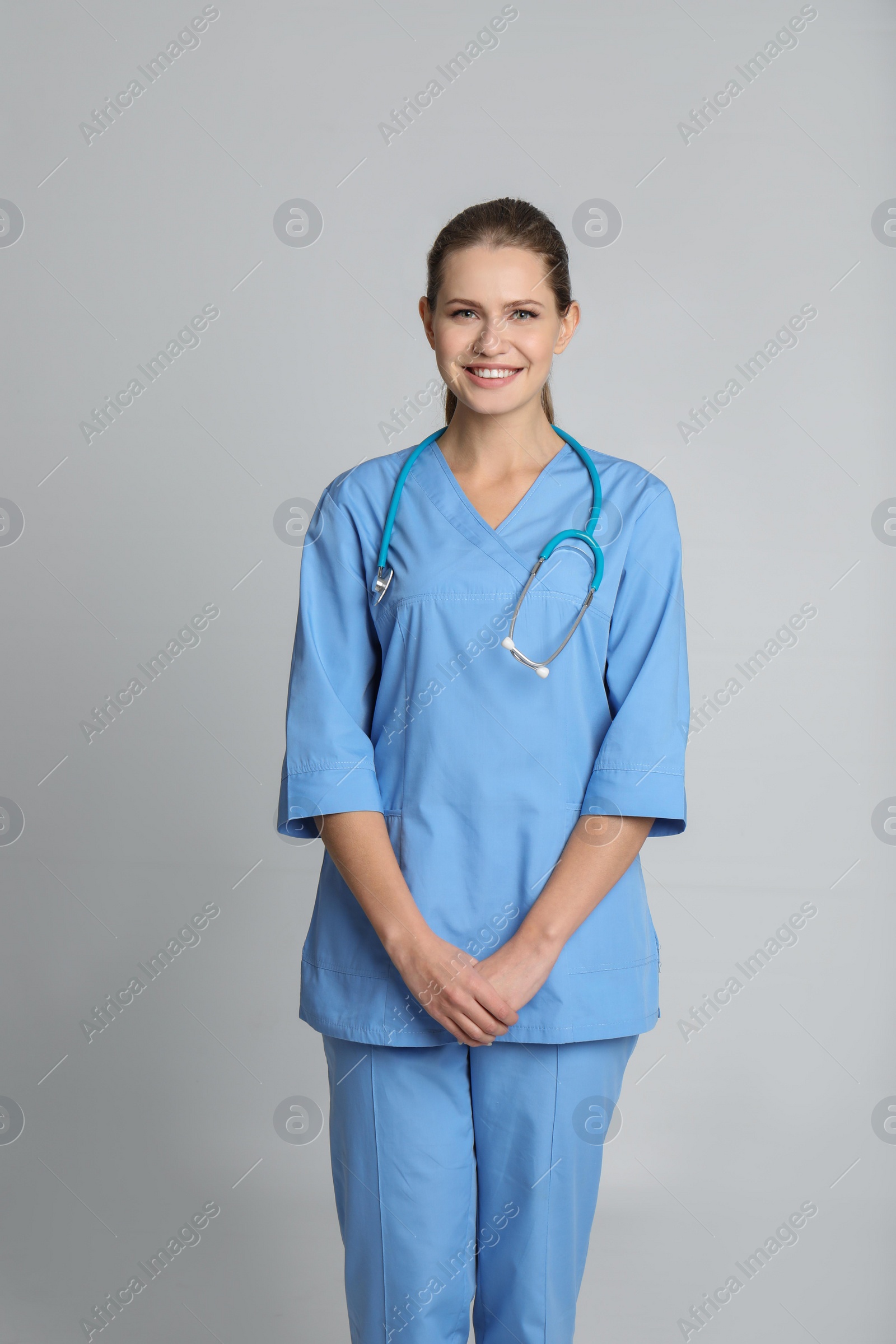 Photo of Portrait of young medical assistant with stethoscope on color background