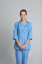 Photo of Portrait of young medical assistant with stethoscope on color background