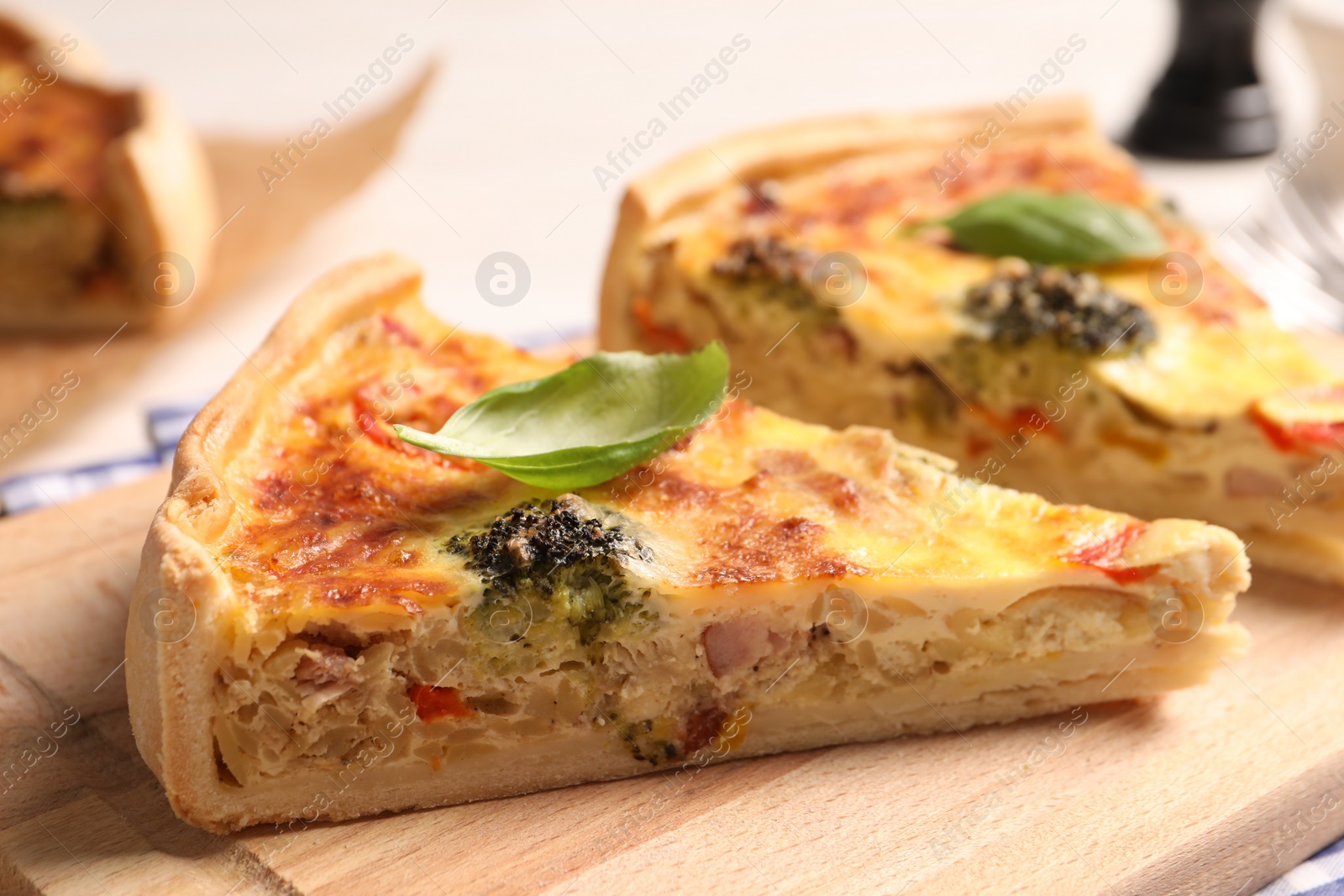 Photo of Delicious homemade vegetable quiche on wooden board, closeup