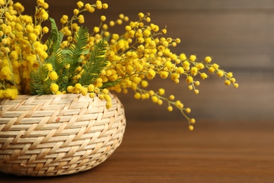 Photo of Bouquet of beautiful mimosa flowers on wooden table