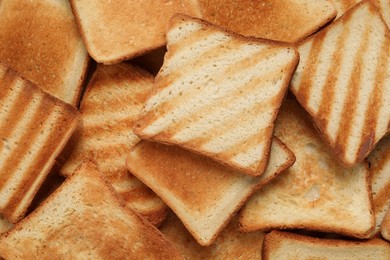 Photo of Slices of tasty toasted bread as background, top view