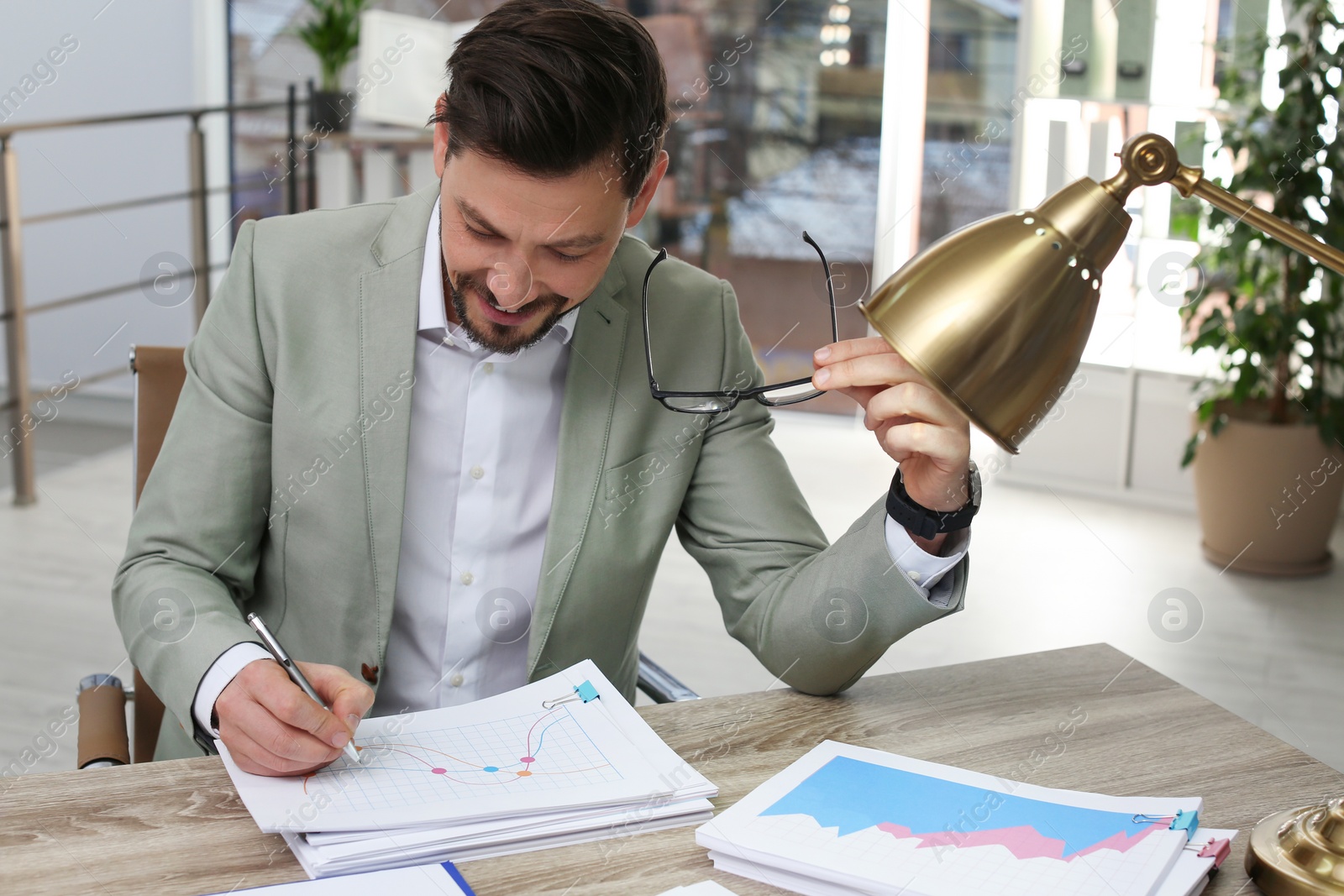 Photo of Businessman working with documents at table in office