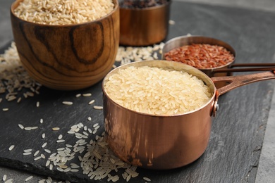 Photo of Measuring cup with uncooked rice on slate plate