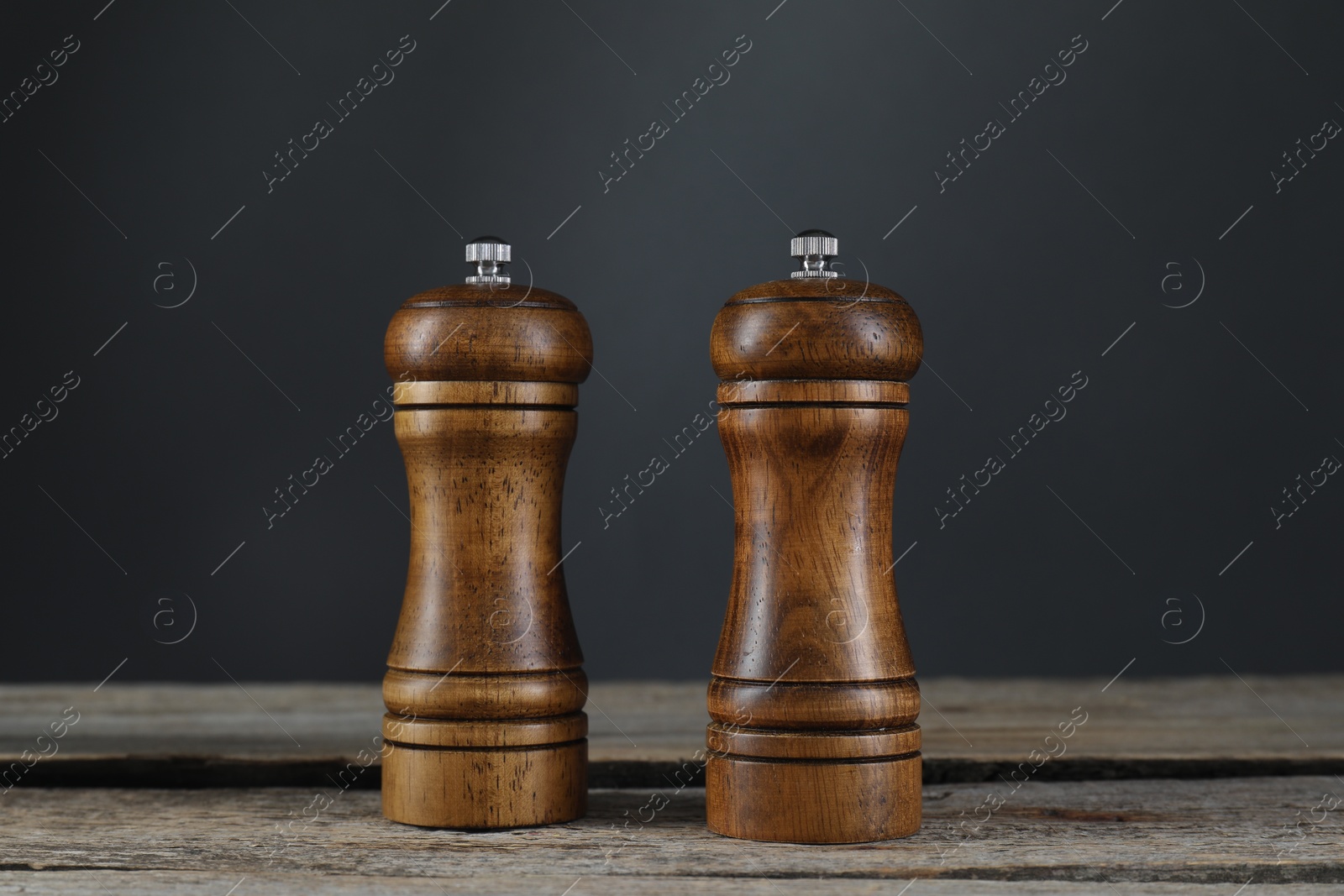 Photo of Salt and pepper shakers on wooden table, closeup